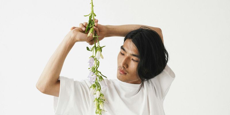 Person holding a stable, balanced pose against a minimal background.